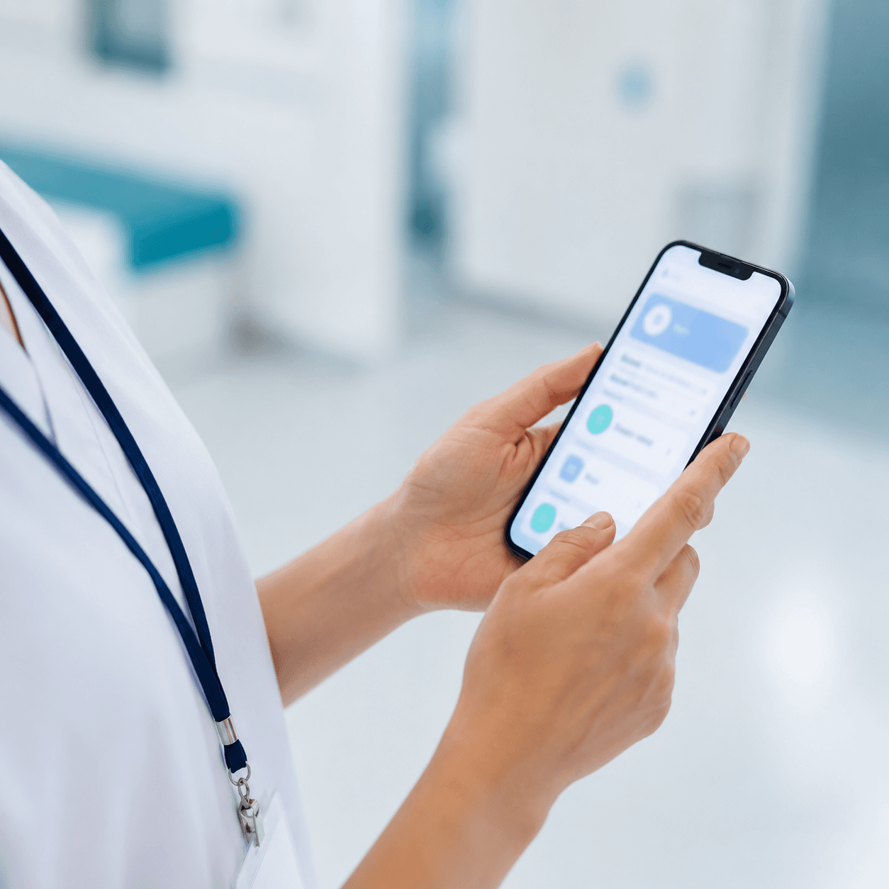 Main d'une infirmière tenant un smartphone affichant l'application OrientaSanté